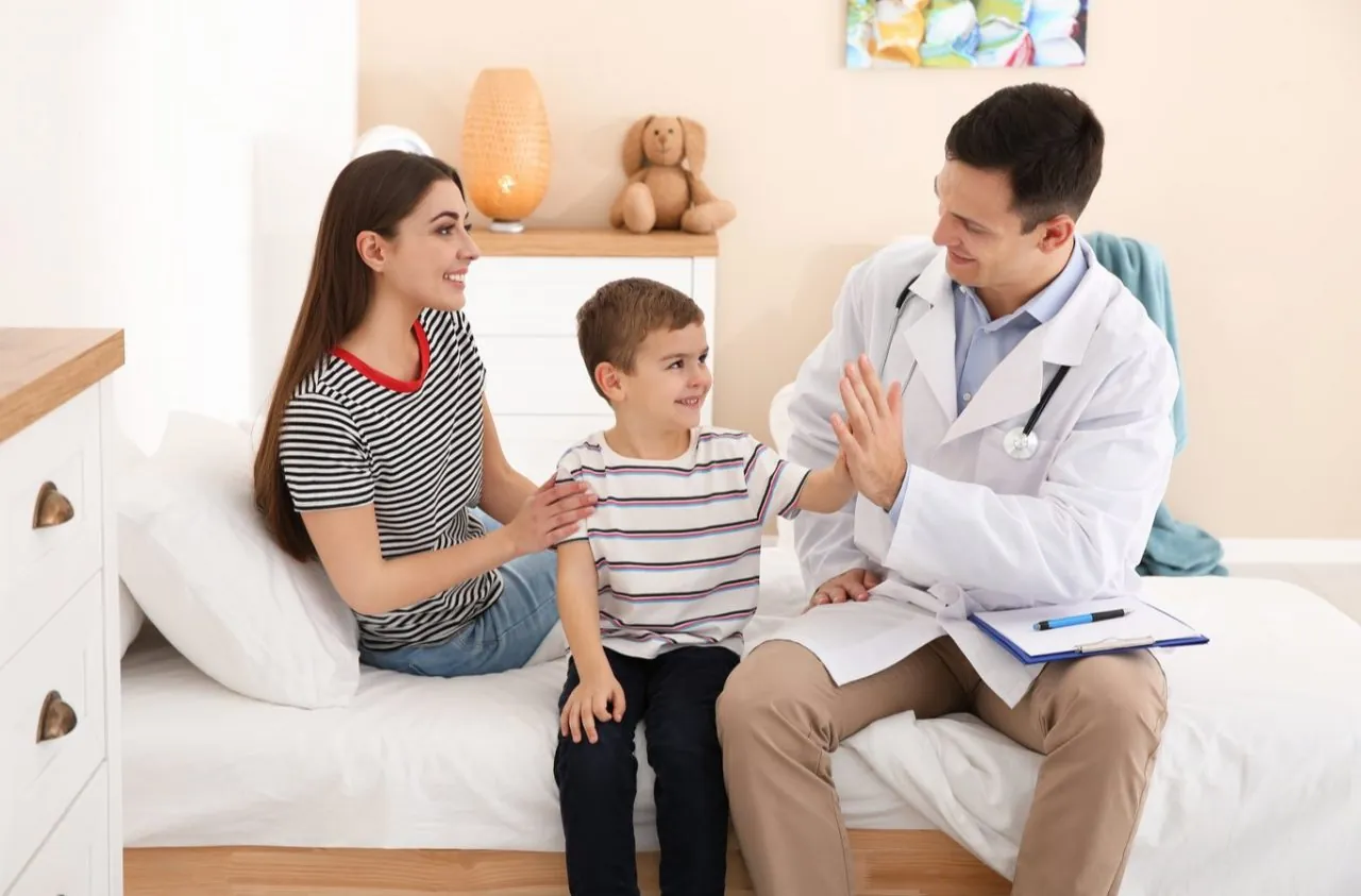 Médico de Medical Home Gdl atendiendo a un niño en su casa, acompañado de su mamá