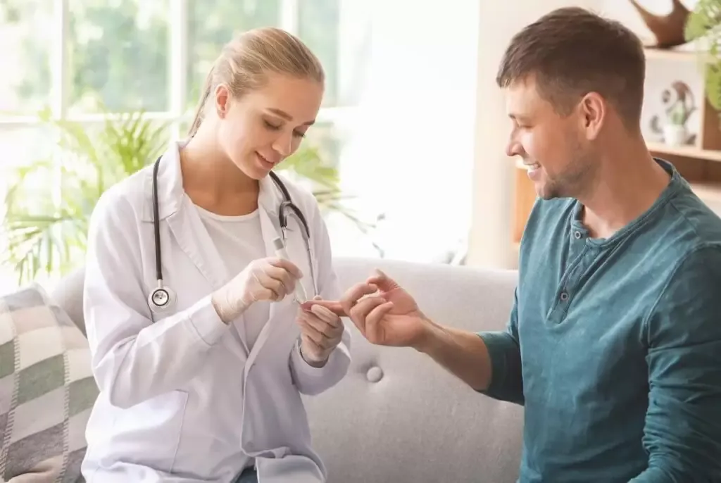Doctora realizando una prueba rápida con punción en el dedo a un paciente en su casa