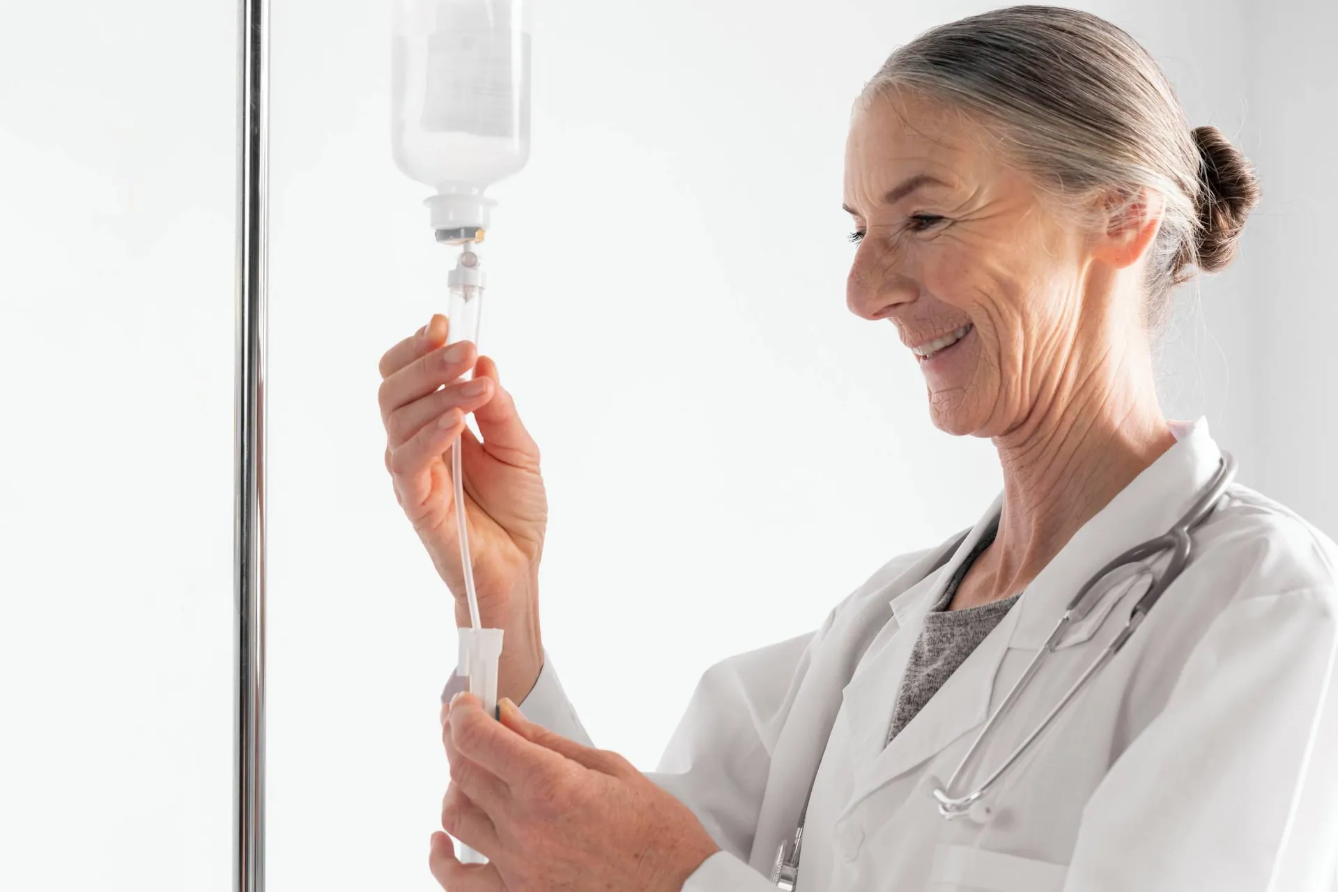 Médica ajustando el goteo de un suero intravenoso en el domicilio del paciente
